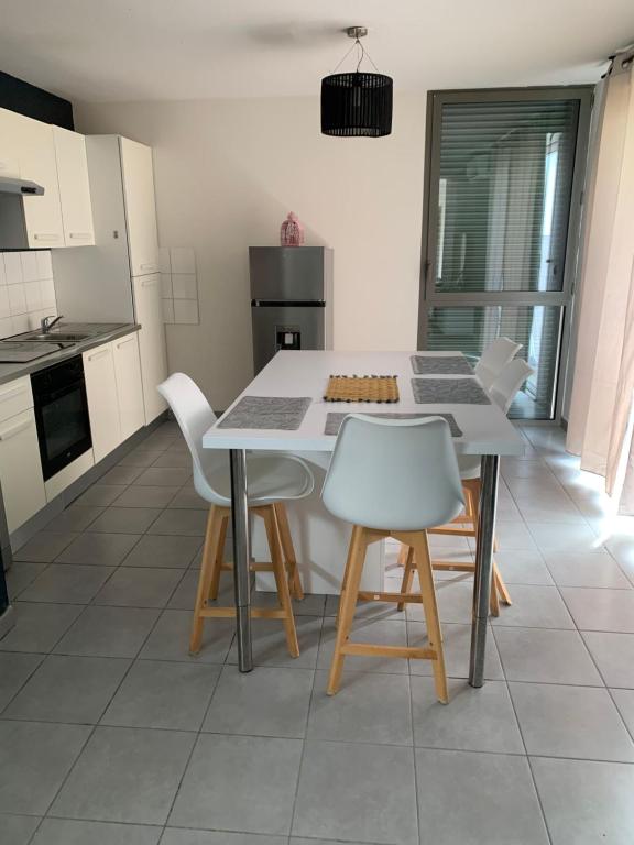 uma cozinha com mesa e cadeiras num quarto em Superbe appartement avec terrasse em Toulouse