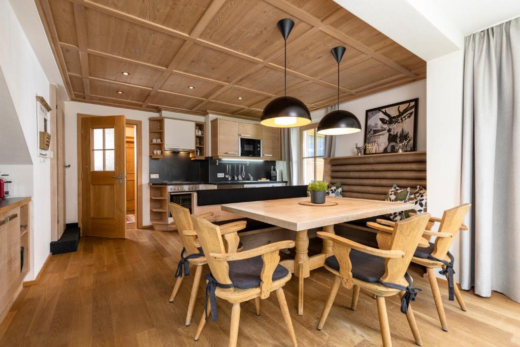 eine Küche und ein Esszimmer mit einem Holztisch und Stühlen in der Unterkunft Landhaus Dorfbäck in Stumm