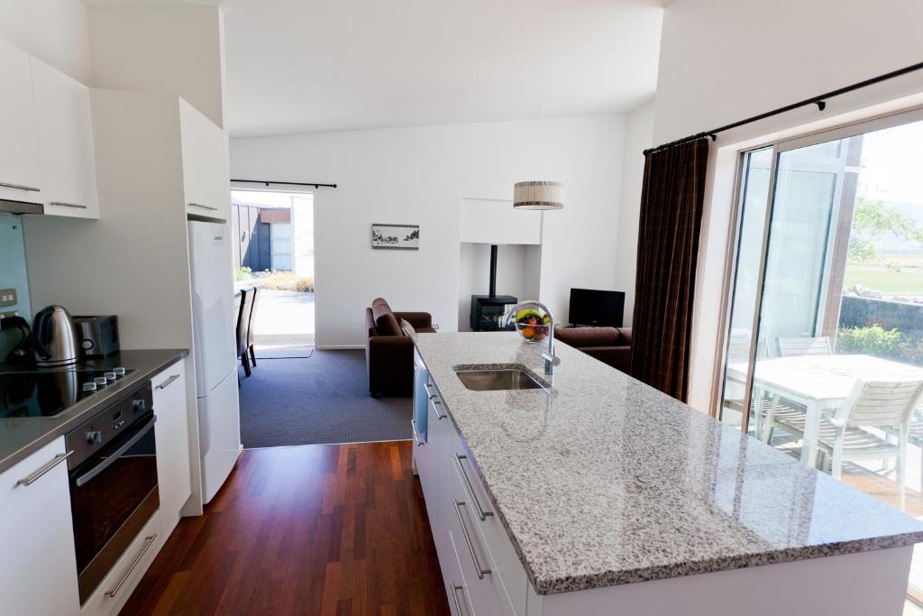 a kitchen with a counter top and a living room at Ski Time in Methven