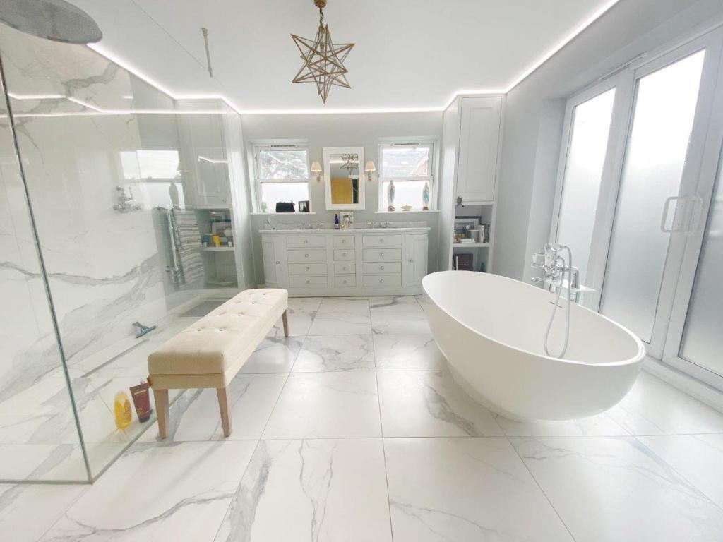 biała łazienka z wanną i prysznicem w obiekcie Entire seaside Luxury home with on site parking! w Poole