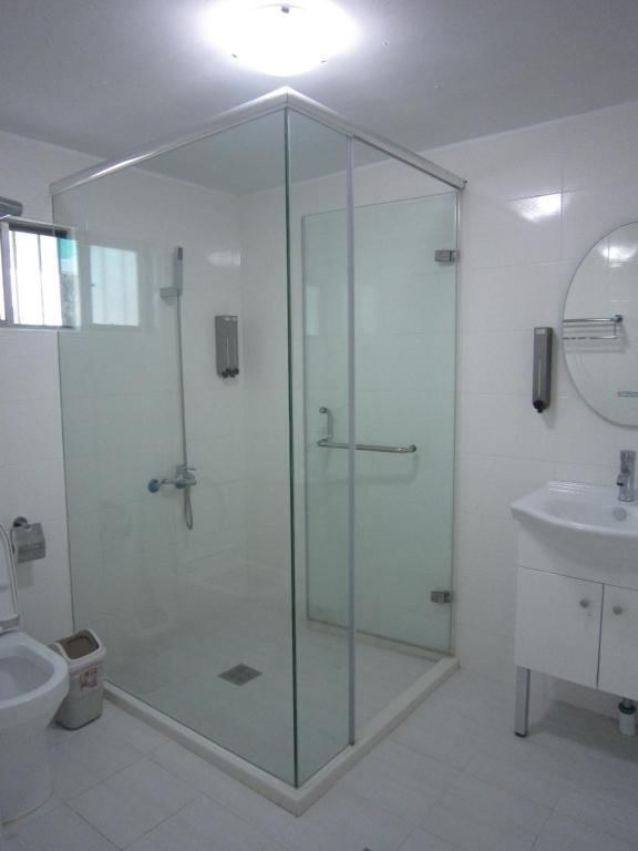 a glass shower in a bathroom with a sink at Amy Walker B&amp;B in Taimali