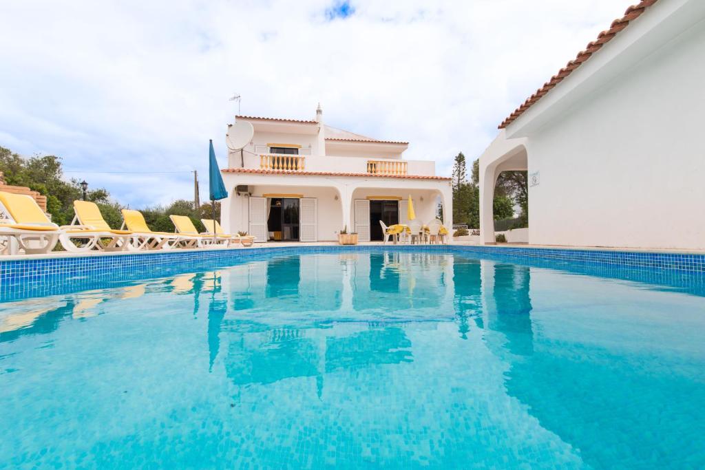 una piscina de agua azul frente a una casa en Casa das Figueiras en Guia