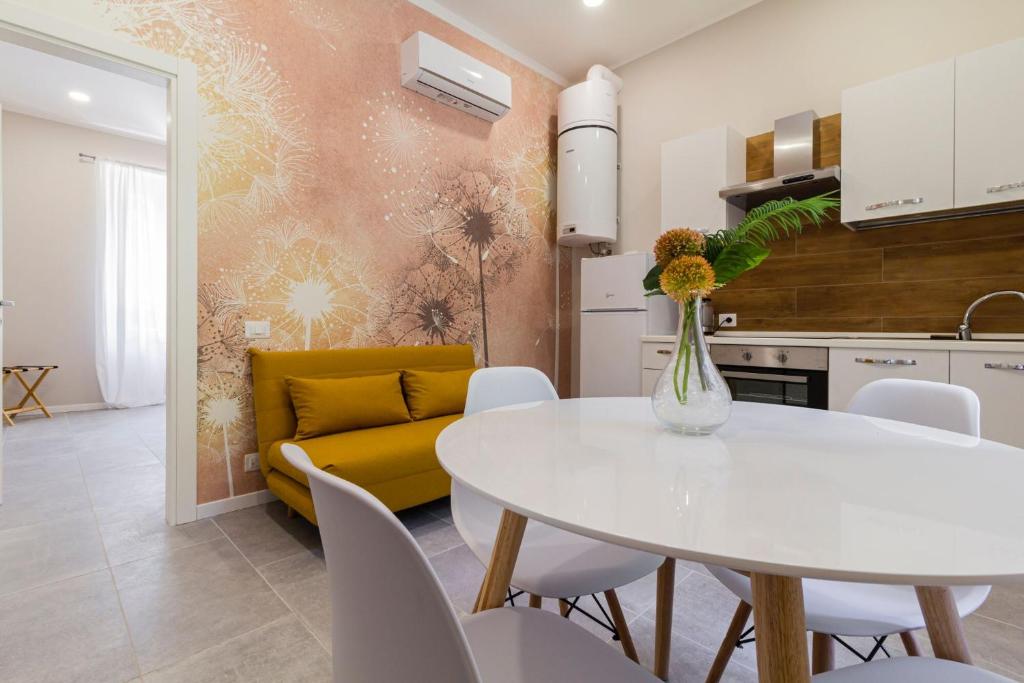 cocina y sala de estar con mesa blanca y sofá amarillo en Luce Marmore, en Le Marmore