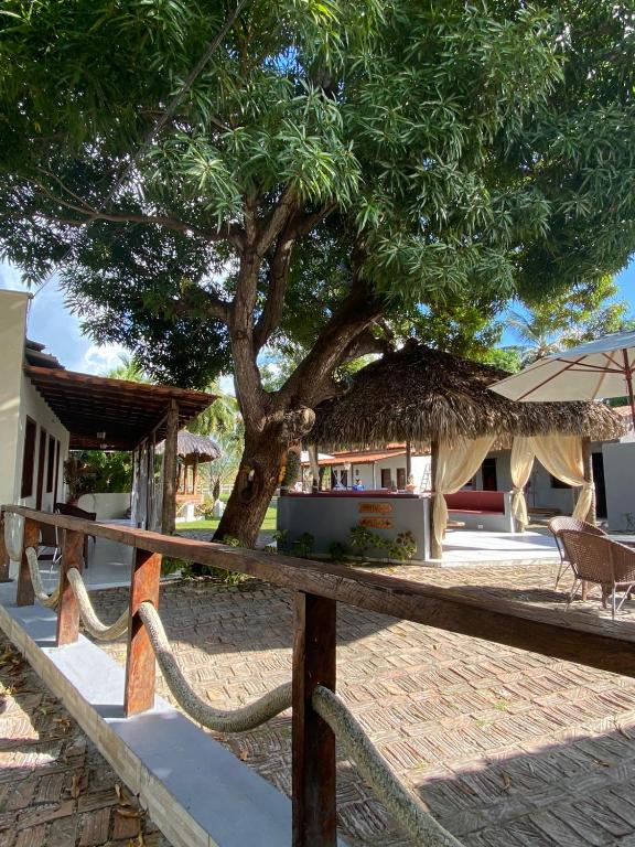 a tree in front of a house with a fence at Pousada Paraiso - Santo Amaro Centro - perto de tudo in Santo Amaro