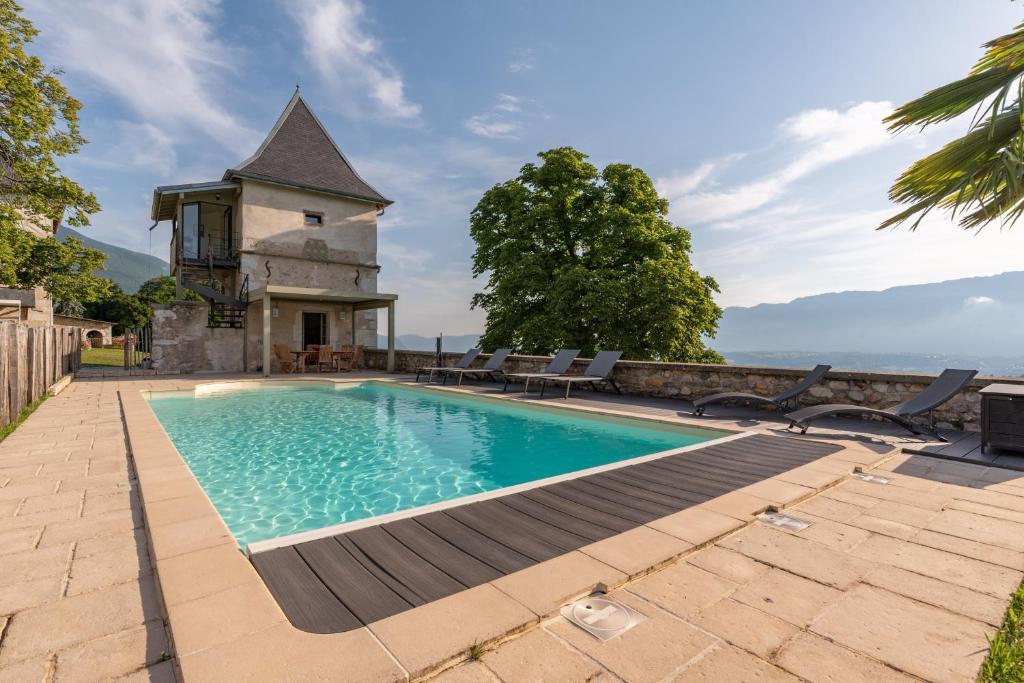 - une piscine en face d'une maison avec une tour dans l'établissement Les Tours Carrées, à La Motte-Servolex
