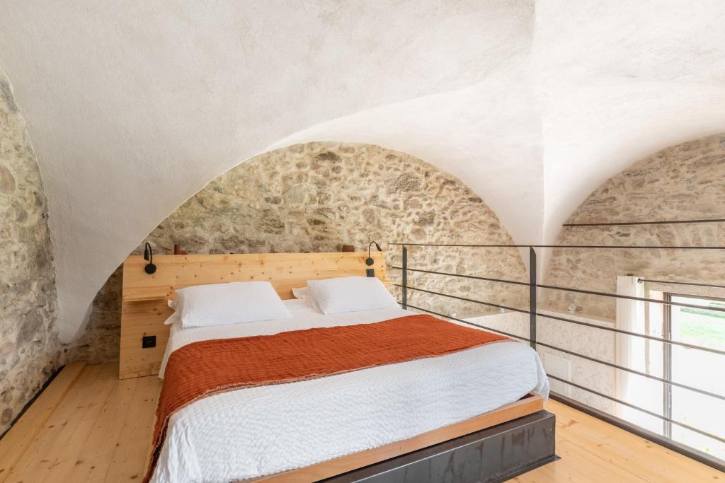a bedroom with a bed and a stone wall at Les Tours Carrées in La Motte-Servolex