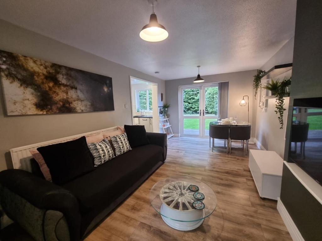 a living room with a couch and a table at Park View Garden apartment in Salfords