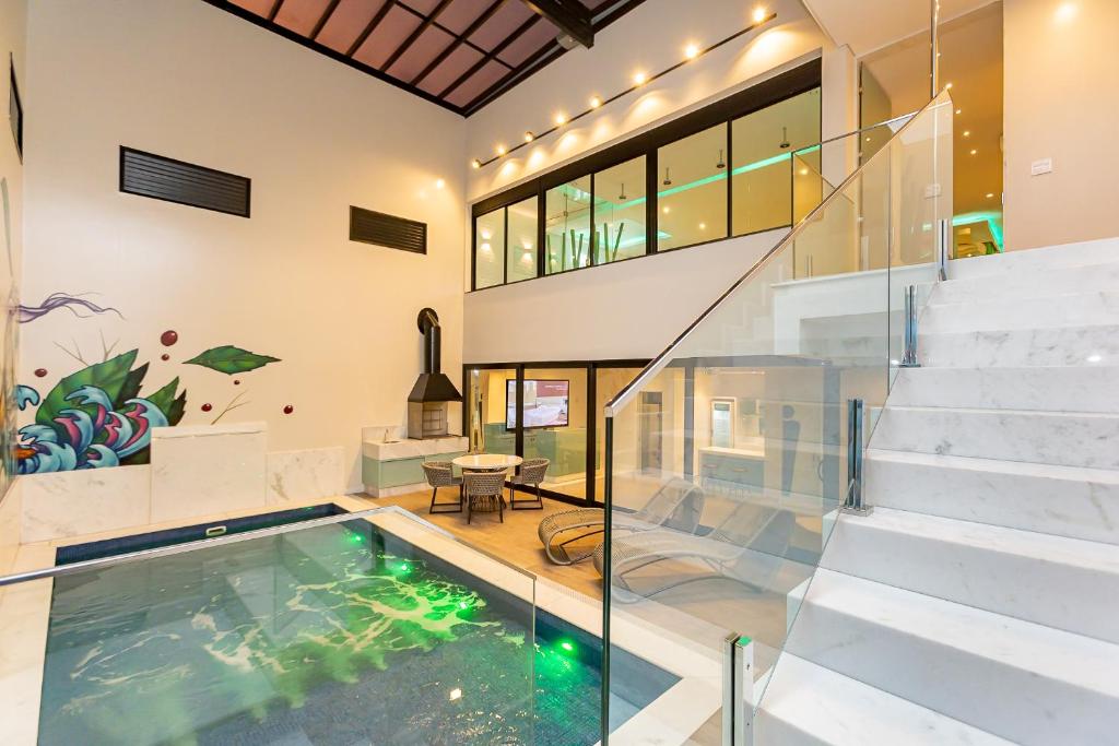 una piscina cubierta en una casa con suelo de cristal en Poeme Motel by Drops en São José dos Pinhais