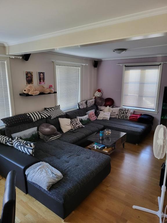 a living room with a black couch and a table at Sentrumsleilighet med gratis parkering til leie in Arendal