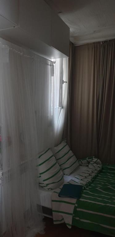 Ce lit se trouve dans un dortoir doté d'une fenêtre et d'une banquette-lit. dans l'établissement Chez André, à Paris