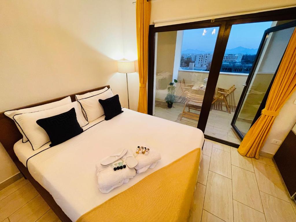 a bedroom with a bed with towels and a balcony at Luxury Hurghada Self-Catering Apartments & Studios, Al Dau Heights in Hurghada