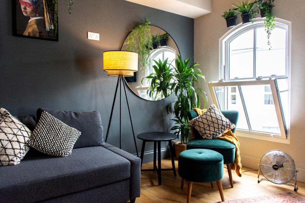 ein Wohnzimmer mit einem Sofa, 2 Stühlen und einem Spiegel in der Unterkunft Plymouth Barbican boutique luxury Apartment in Plymouth