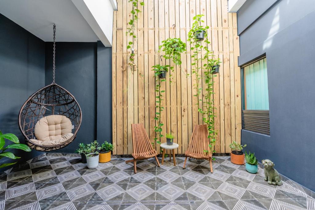 a patio with chairs and a swing and plants at La Buena Vida Inn in San Juan