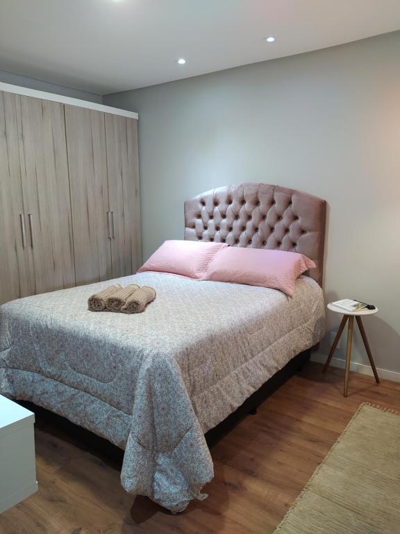 a bedroom with a large bed with pink pillows at Quarto Inteiro Privado - 3km Oktoberfest in Blumenau