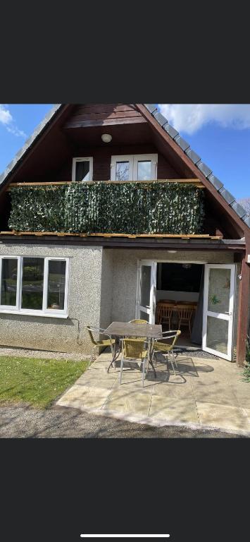 a house with a table and chairs in front of it at 128 Hengar Manor in Bodmin