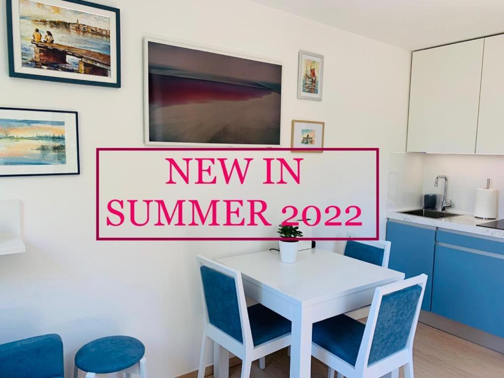 ein neues Schild im Sommer in einer Küche mit Tisch und Stühlen in der Unterkunft Apartma Manuel in Izola