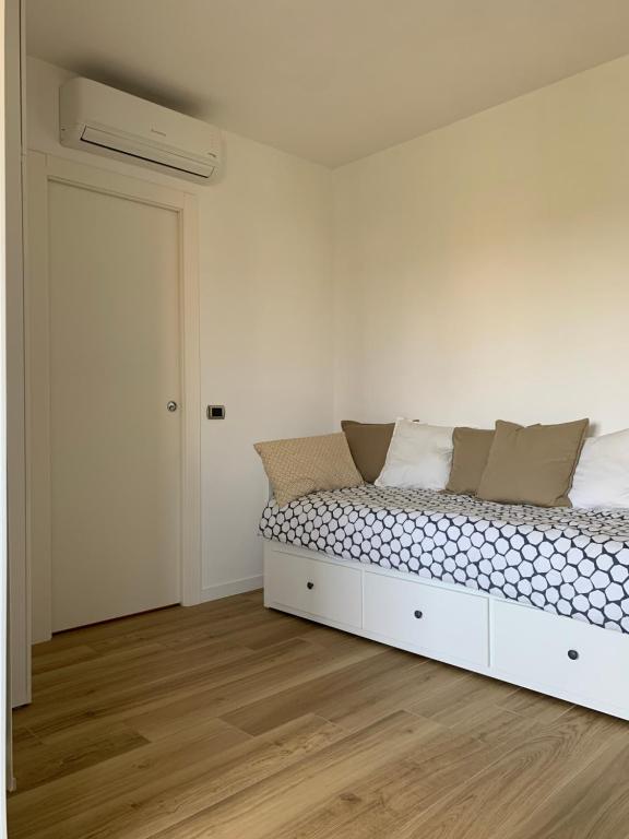 ein weißes Zimmer mit einem Bett und einer Tür in der Unterkunft Stanza Claudina in Rom