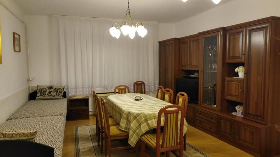 a dining room with a table and chairs and a kitchen at Dapsy Vendégház in Jósvafő