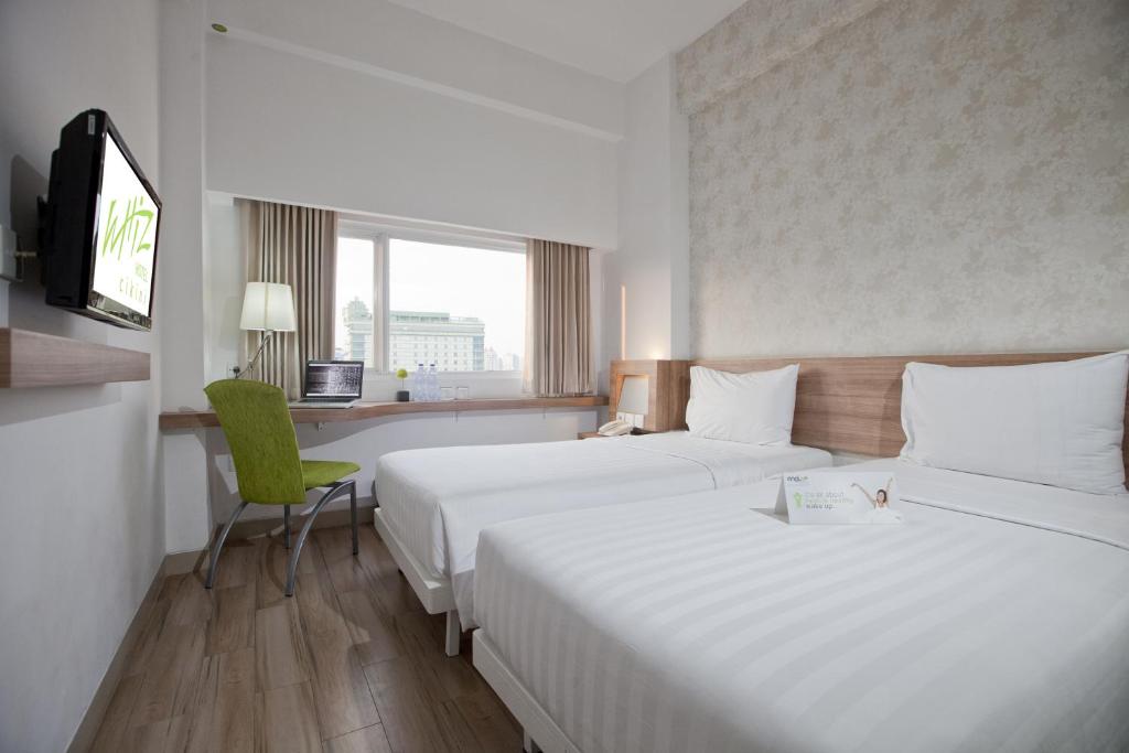 Postel nebo postele na pokoji v ubytování Whiz Hotel Cikini Jakarta