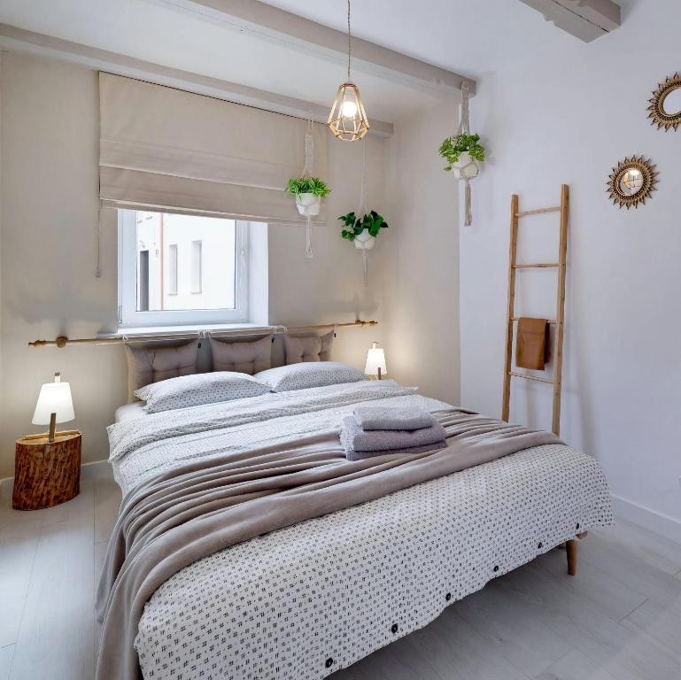 ein weißes Schlafzimmer mit einem großen Bett in einem Zimmer in der Unterkunft CZAS NA GÓRY Jedlina-Zdrój. Apartament na 5 in Jedlina-Zdrój