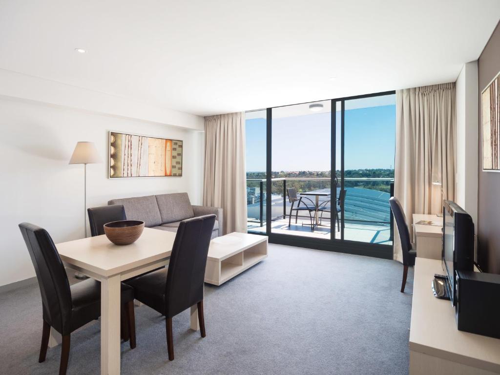 
a living room with a couch, chairs and a table at Oaks Adelaide Horizons Suites in Adelaide
