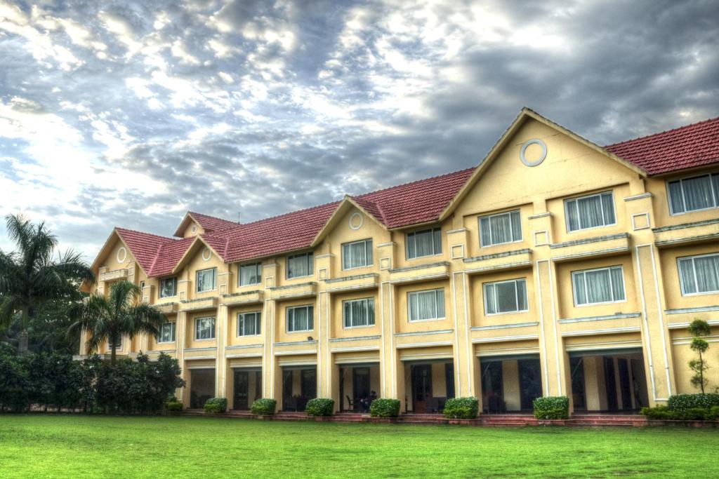 a large building with a green field in front of it at Country Roads in Howrah