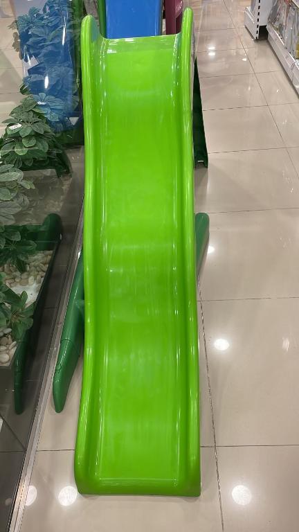 a green plastic chair sitting on the floor in a store at فيلا بسين خاص in Dawwār Abū Maḩrūs