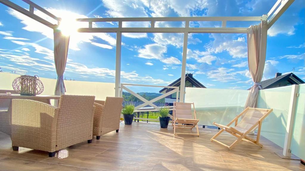 eine Terrasse mit Stühlen und Meerblick in der Unterkunft Biały Domek Aleja Lipowa 73D in Zwierzyniec