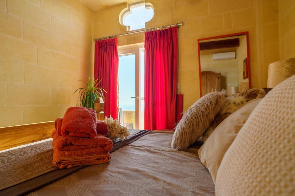 a living room with a couch with red curtains at Ajuga Luxury Boutique B&B in Qala
