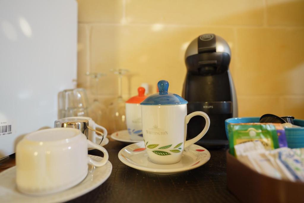 a counter top with two cups and a tea kettle at Ajuga Luxury Boutique B&B in Qala