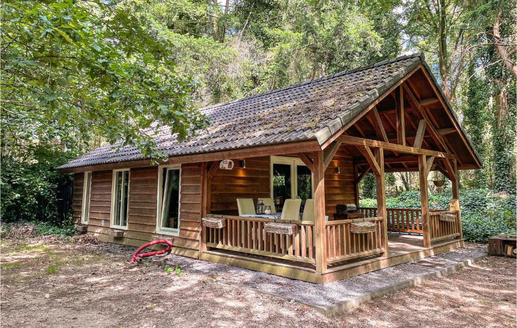 eine Holzhütte mit einer Terrasse im Wald in der Unterkunft Lake Front Home In Grathem With Kitchen in Grathem