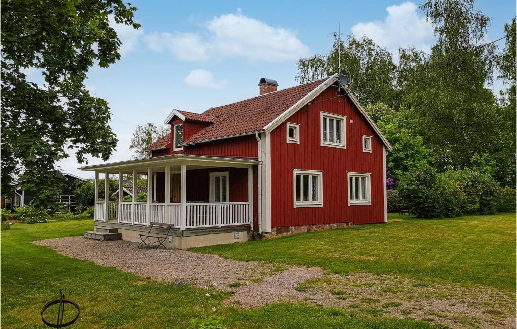 una casa roja con un porche blanco en un patio en 3 Bedroom Awesome Home In Vxj, en Växjö