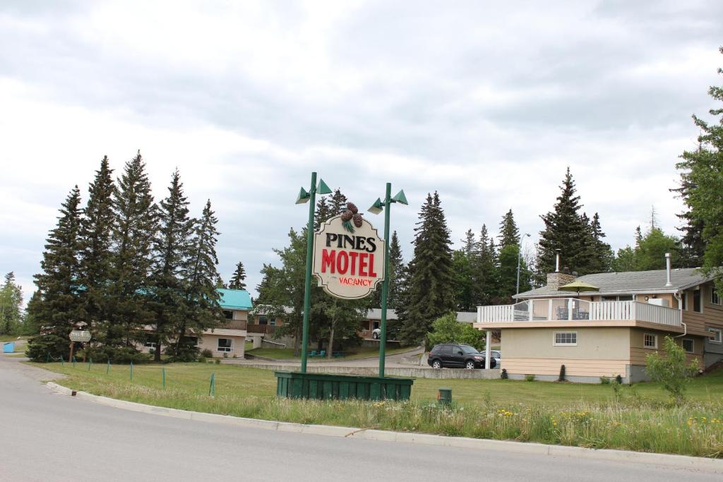a sign for a pine motel on the side of a road at Pines Motel in Hinton