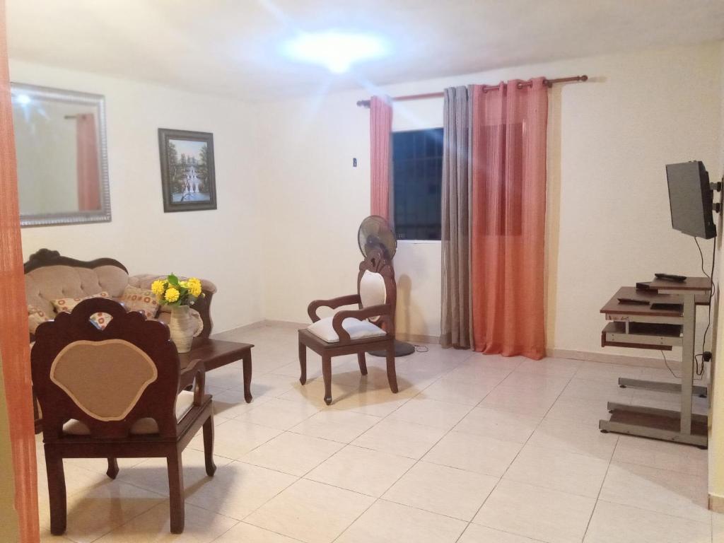 a living room with a woman sitting on a chair at Apartamento en Santo Domingo Este, Urbanización moises, a 40 minutos playa boca chica in Santo Domingo