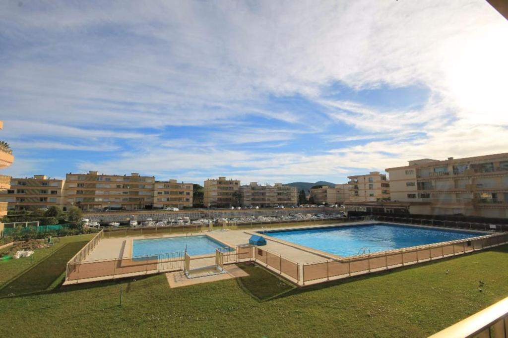 a large swimming pool in a city with buildings at MARCO POLO - Studio privé avec piscine et parking in Mandelieu-La Napoule