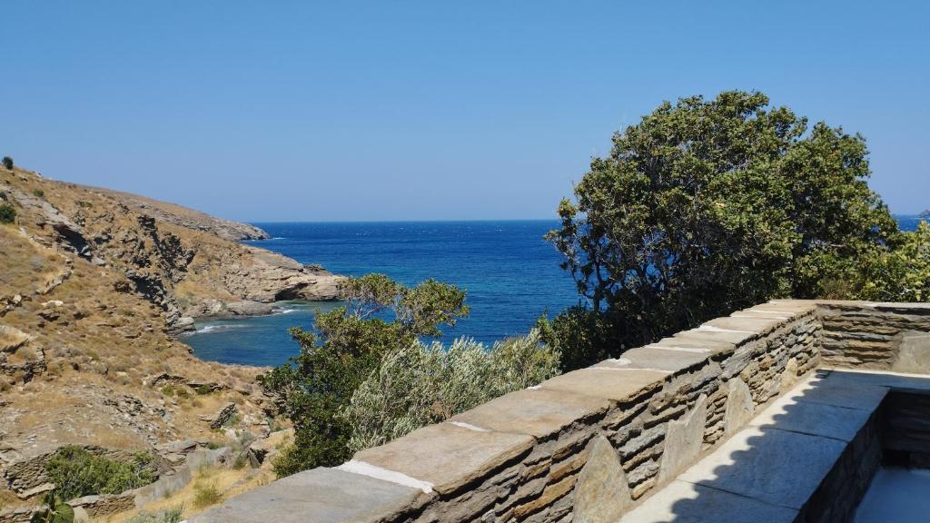 - un mur en pierre avec vue sur l'océan dans l'établissement Villa Kalamonari nature house, cycladic wilderness, à Rogón