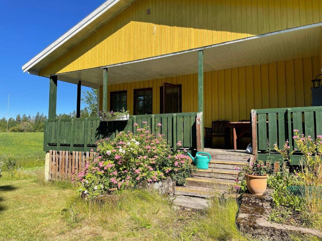 a house with a porch with flowers in front of it at Holiday home BENGTSFORS VI in Bengtsfors