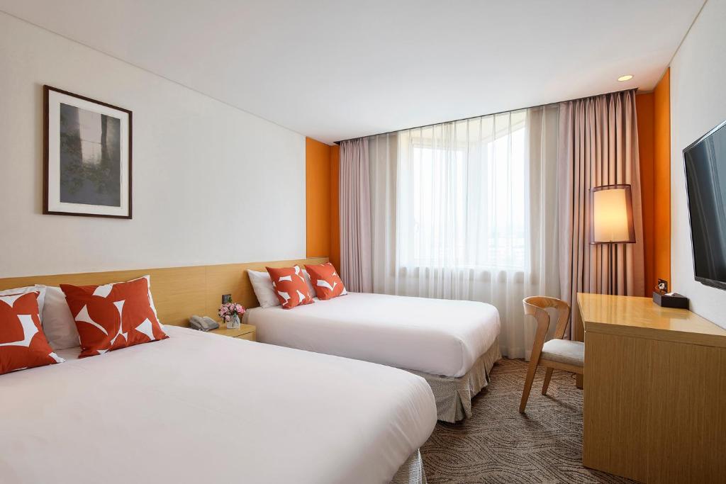 Postel nebo postele na pokoji v ubytování Jeju Central City Hotel