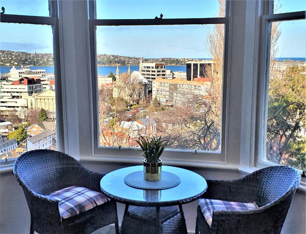 a table and chairs in a room with windows at Work Stay at 123 in Dunedin