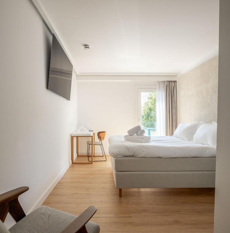 a white bedroom with a bed and a window at Hotel Boutique Berazadi Berri in Zarautz
