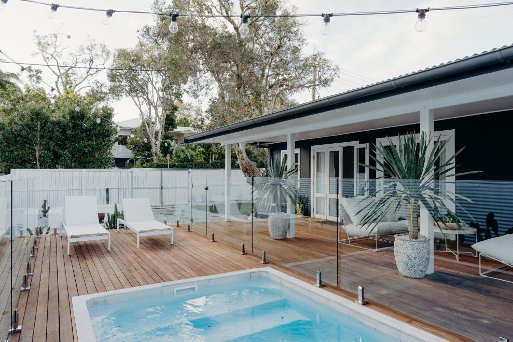 una terraza con piscina y una casa en Soul, en Byron Bay