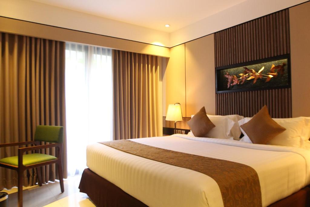 A bed or beds in a room at The Nest Hotel Nusa Dua
