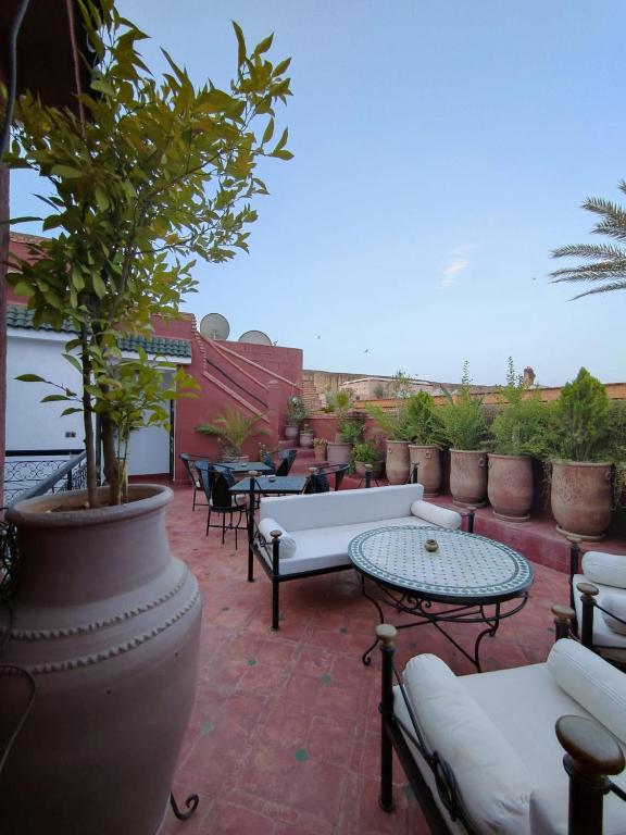 a patio with couches and tables and potted plants at Riad Assalam in Marrakech