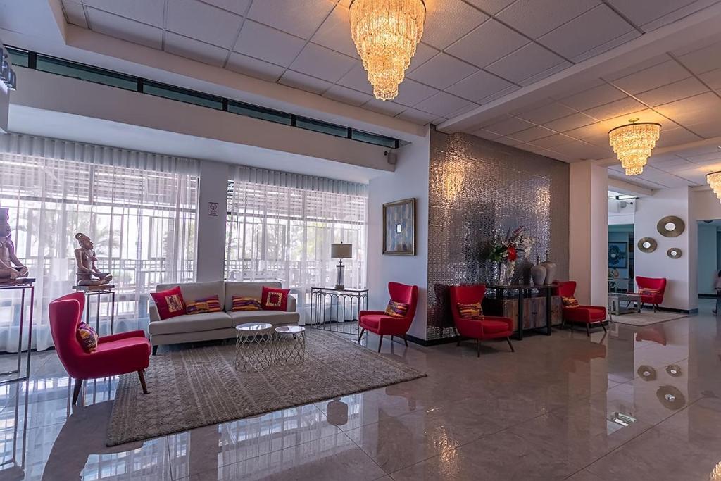 a lobby with red chairs and a couch and a table at Apartamento Riviera, lake Panajachel in San Jorge La Laguna