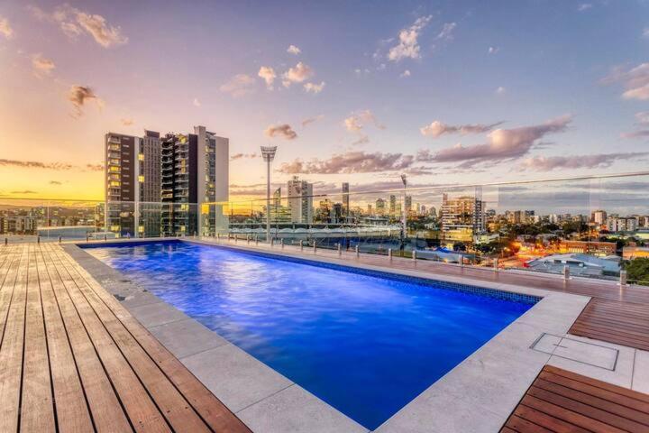 a large blue swimming pool on top of a building at Inner city 1 bedroom Apartment with Rooftop pool and Parking - Serain Residences in Brisbane