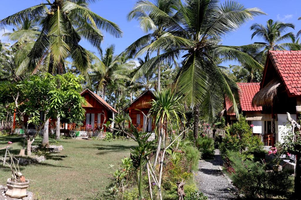 a resort with palm trees in front of a yard at Dangin Kubu Bungalow in Nusa Penida