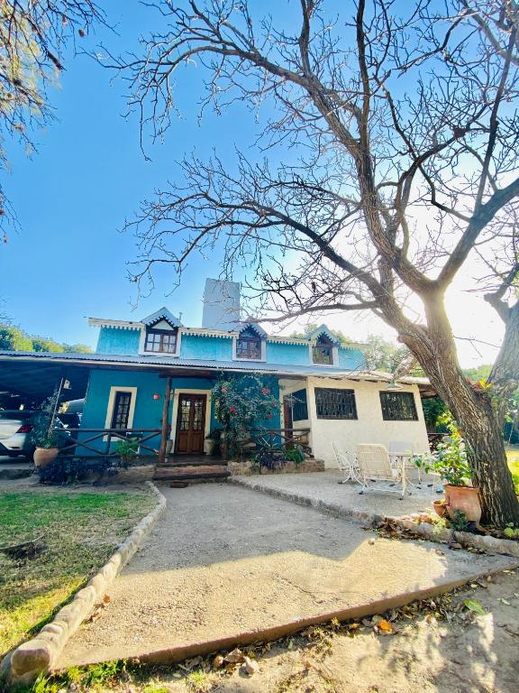 a blue and white house with a tree at Hospedaje Casa Azul in Villa Allende
