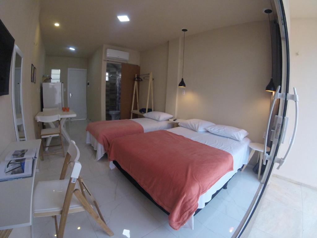 Habitación hospitalaria con 2 camas y espejo en Flats Taiba Praia Centro, en Taíba