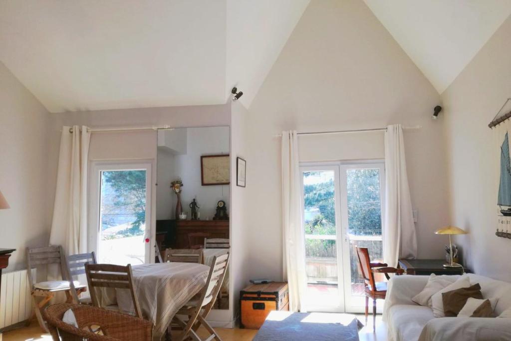 a living room with a couch and a table at Beautiful house facing the alder wood and beach in La Baule