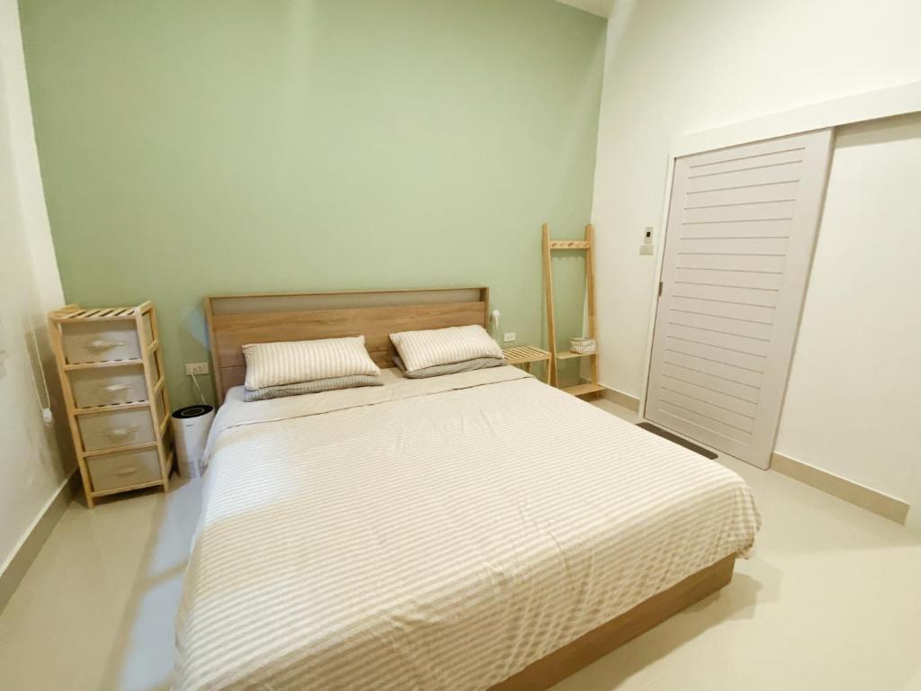 a bedroom with a large bed and a night stand at Sundae Haus in Betong